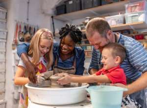 Two adults and two kids doing pottery.